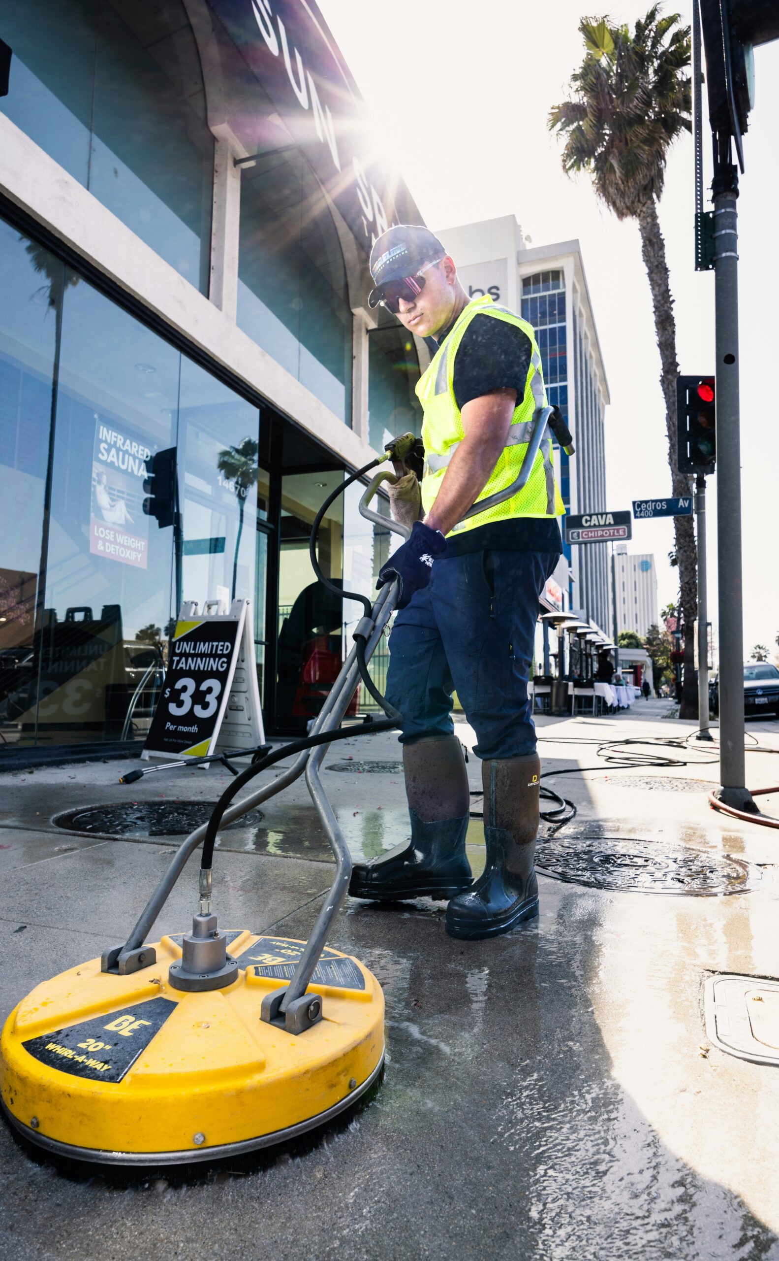 a man in a yellow vest is cleaning the street